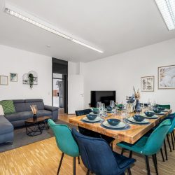 Living room with large dining table, sofa, and smart TV Wohnzimmer mit großem Esstisch, Sofa und Smart-TV