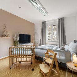 Bedroom with child fall protection, high chair, and crib Schlafzimmer mit Kinderrausfallschutz, Hochstuhl und Babybett