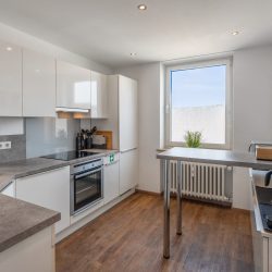 Vollausgestattete Küche mit Herd, Backofen, Mikrowelle, Toaster, Kaffeemaschinen, Kochutensilien, Spülmaschine und Kühl-/Gefrierschrank.