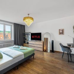 Einzelschlafzimmer mit Kingsize-Doppelbett, 50-Zoll-Smart TV, Gaderobe und Arbeitsplatz.