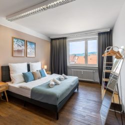 Einzelschlafzimmer mit Kingsize-Doppelbett, Spiegel und Garderobe.