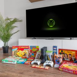 Spielesammlung mit xBox 360, Brettspielen und Büchern.